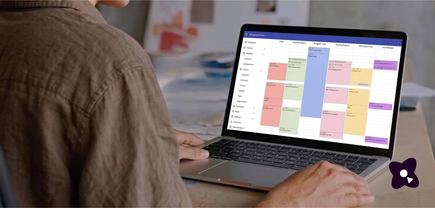 A community manager at a laptop showing the Cothena management panel, with a colour-coded schedule of sessions laid out side by side across six tracks.
